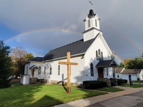Church building exterior with cross on the lawn